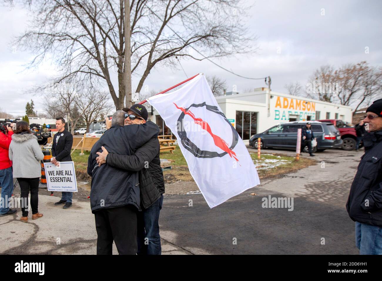 Anti-lockdown protesters hug outside Adamson Barbecue, which opened for indoor dining despite a reintroduction of coronavirus disease (COVID-19) restrictions in the Etobicoke suburb of Toronto, Ontario, Canada November 24, 2020.  REUTERS/Carlos Osorio Stock Photo