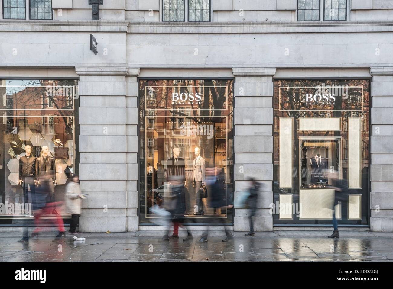 People shopping in Sloane Square, walking past the Hugo Boss shop, London, England Stock Photo