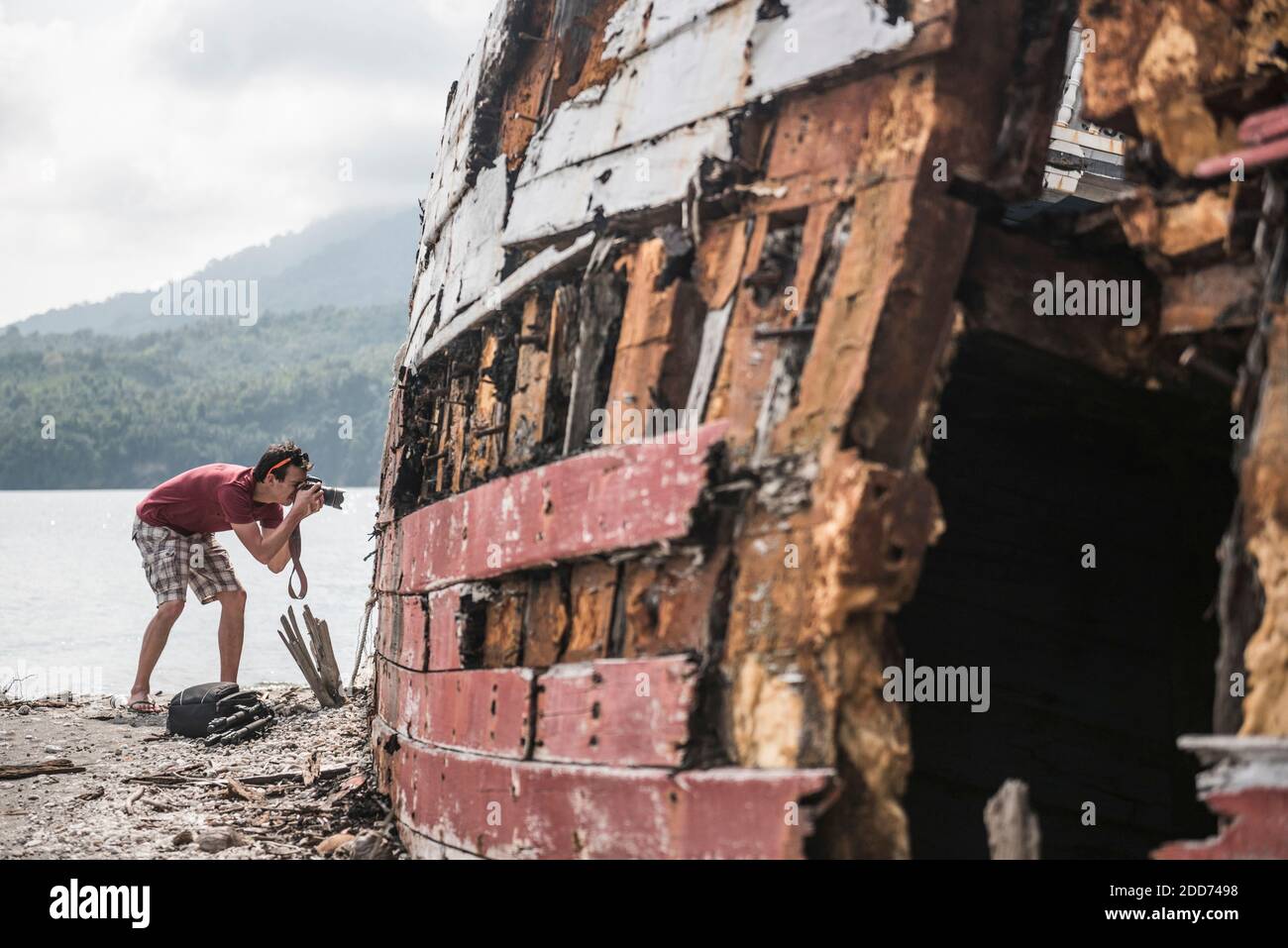 Photographer taking a photo of a shipwrecked fishing boat, Pulau Weh