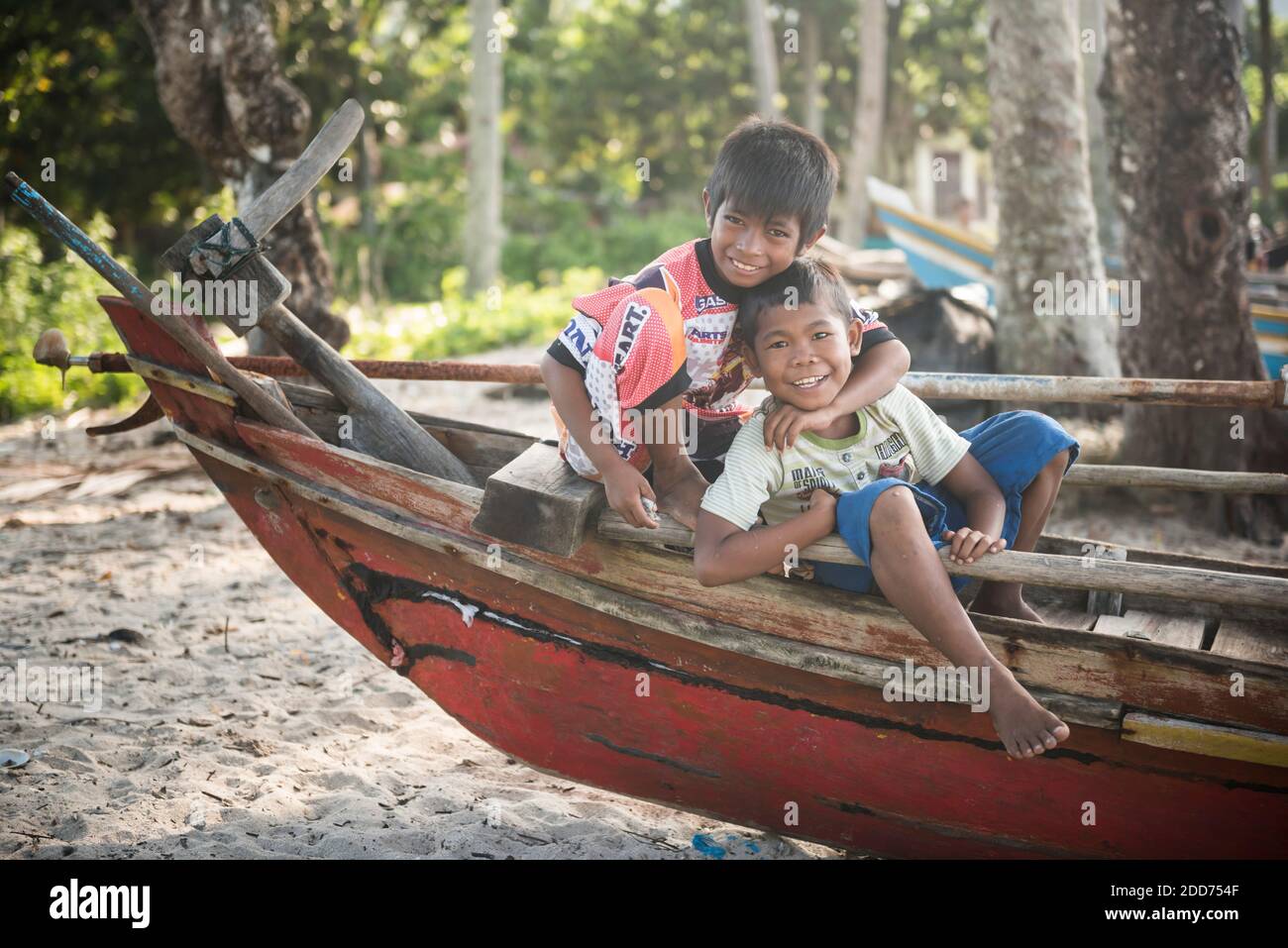 Children playing on a traditional fishing boat at Sungai Pinang Fishing Village, near Padang in West Sumatra, Indonesia, Asia Stock Photo