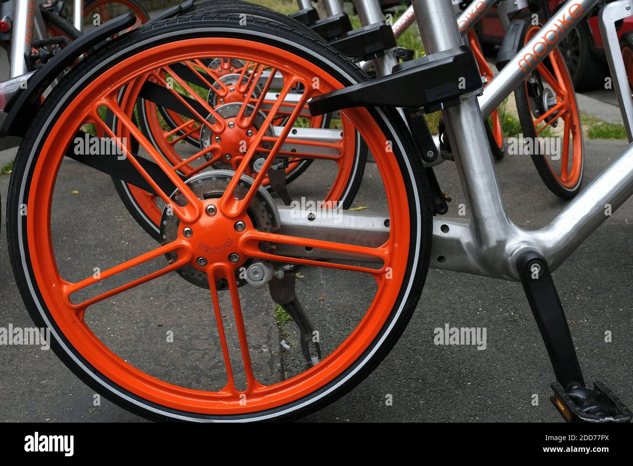 Mobike (orange) bicycle a Chinese bike-sharing service, these bicycles are  accessible and can be dropped off in the street. the bicycles that are  rented via an app that finds the closest bicycle