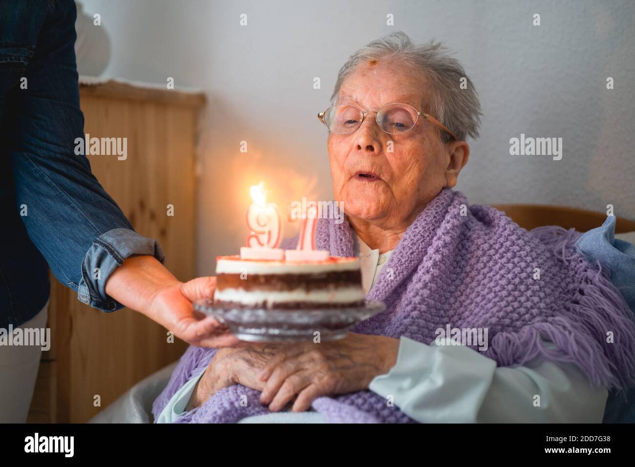 Old woman blows the candles from his 96th birthday cake with daughter Stock Photo Alamy