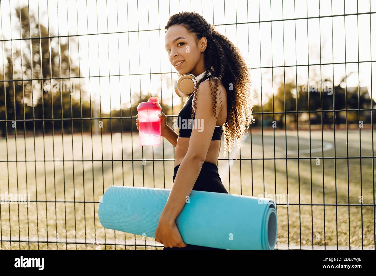 https://c8.alamy.com/comp/2DD7WJB/beautiful-young-athletic-african-american-woman-in-sportswear-holding-a-yoga-mat-and-a-bottle-of-water-outdoors-in-the-park-at-sunrise-2DD7WJB.jpg