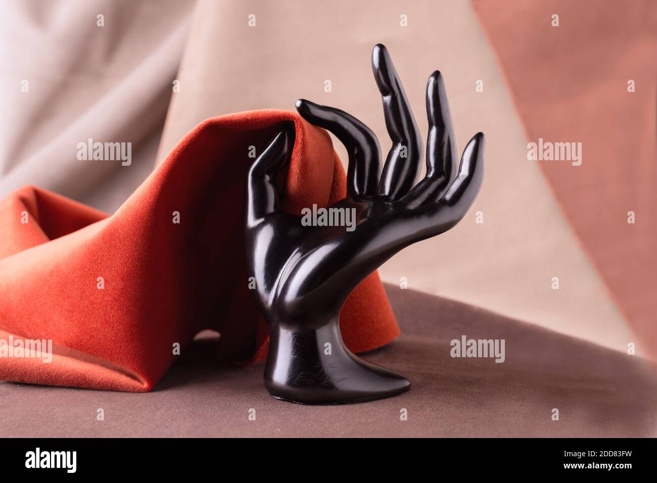Black Plastic Mannequins Hand Holding piece of velour fabric. Fabric background Stock Photo