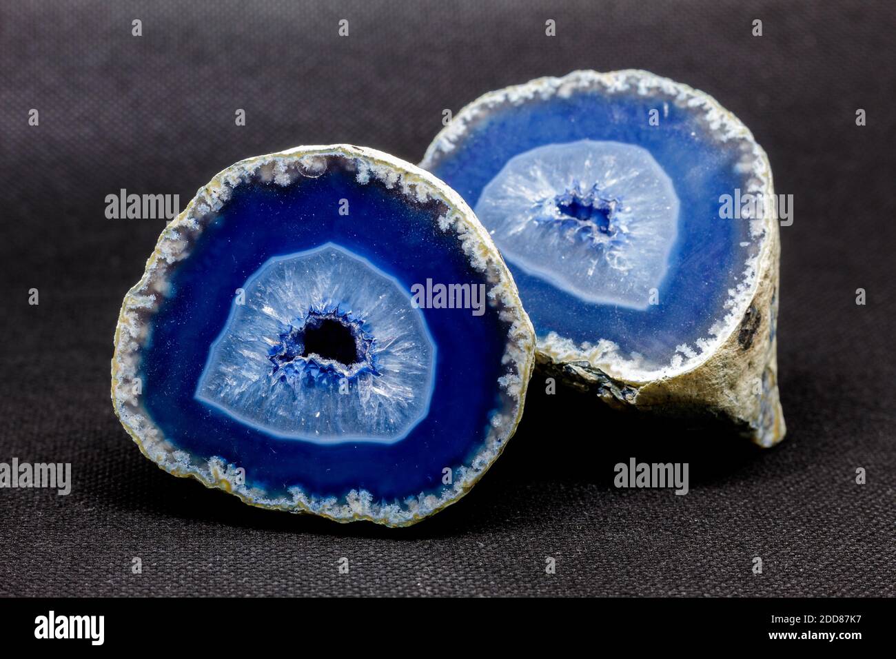 Blue agate stone cut in half. Agate is formed by rhythmic deposition of silica, usually within amygdalar cavities of basalt rocks, or petrified (agati Stock Photo