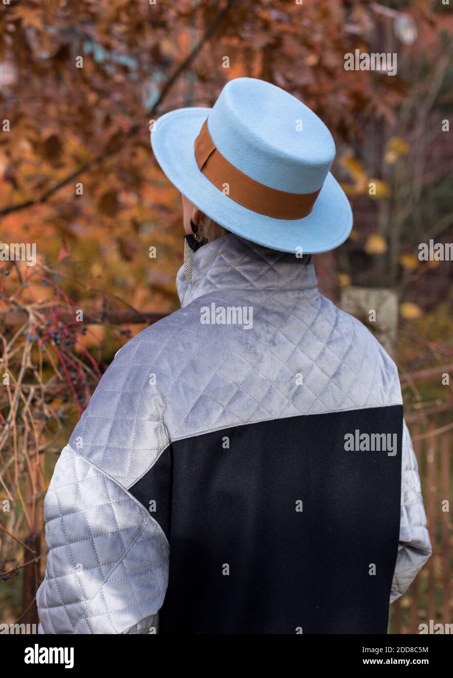 Woman in a blue hat standing with her back. Stock Photo