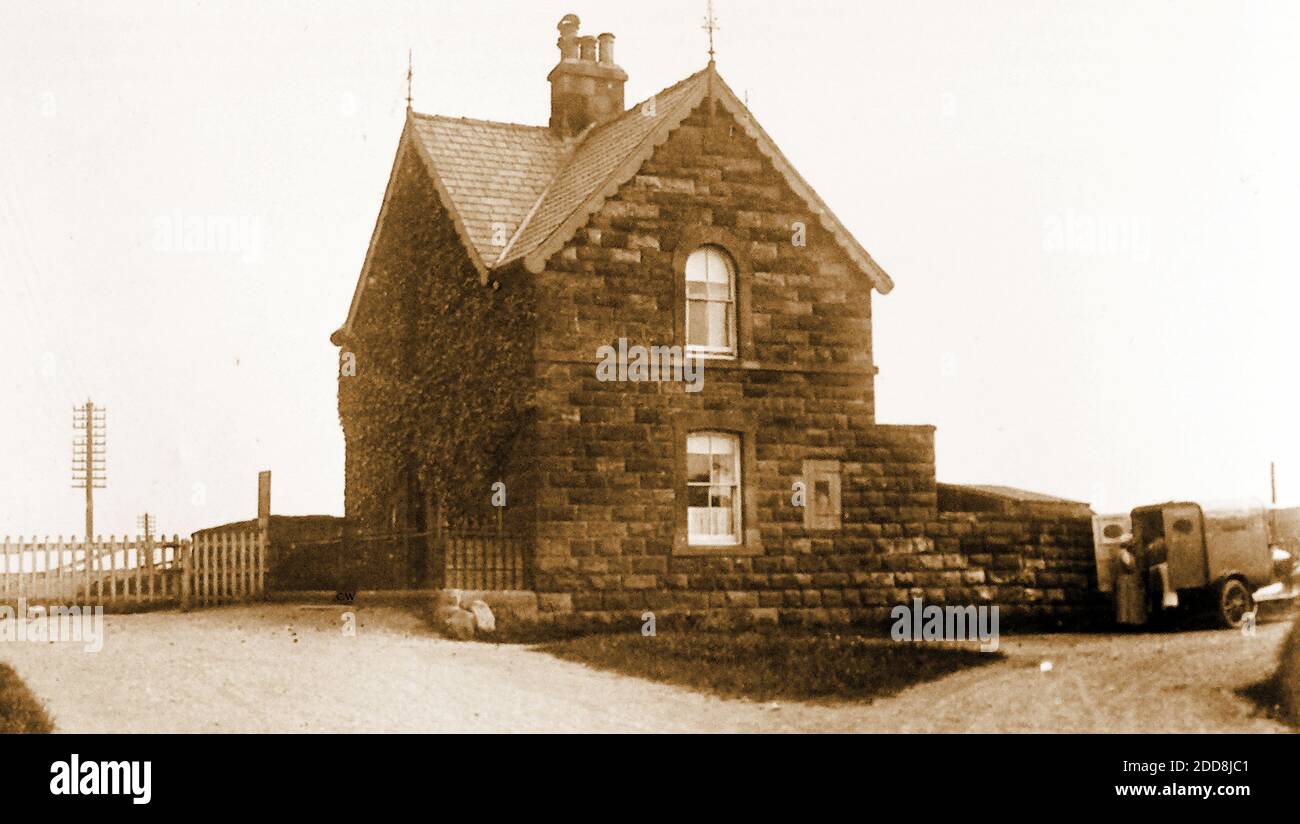 At the Toll bar on the then newly built road between Sandsend and Whitby, North Yorkshire. This photo shows the toll bar house (still in existence as a private residence) with the gate to Whitby (left) and the existing road to Newholm (right) where the delivery van is standing.. A photograph of the board listing toll charges on this road is available on Alamy. Stock Photo