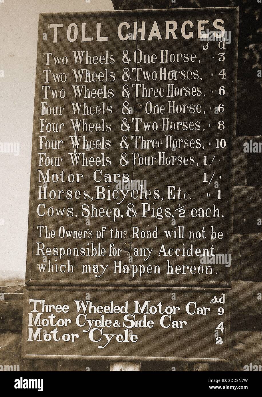 At the Toll bar on the then newly built road between Sandsend and Whitby, North Yorkshire. This photo shows the charges made for both horse-drawn and motor vehicles. Prices are shown in S & D (shillings and pence) and cover everything from three-wheeled cars, to carts, and farm animals. A photograph of the toll booth house is available on Alamy Stock Photo