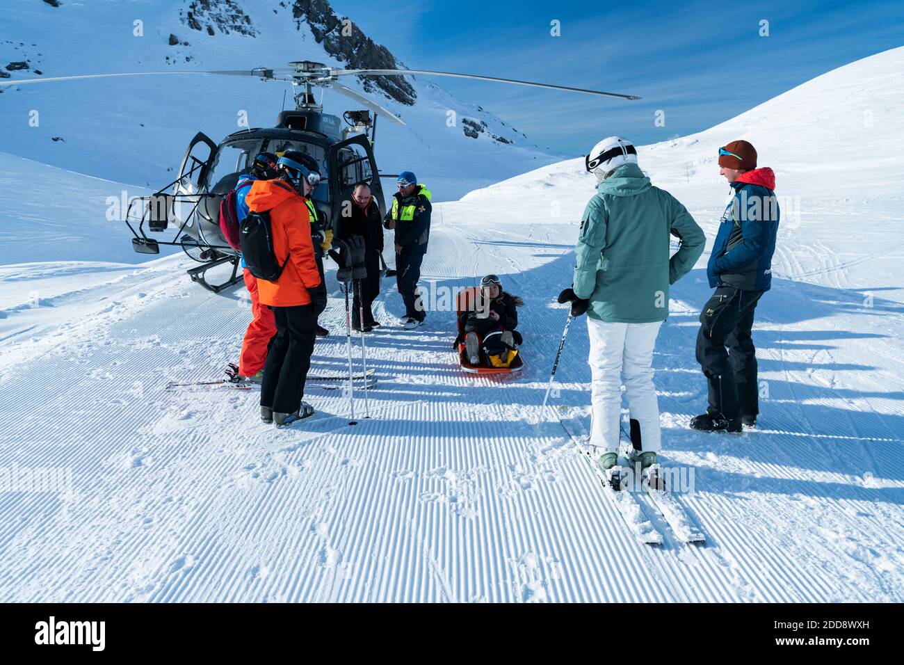 Mountain rescue team with helicopter rescuing an injured skier in a stretcher after having a skiing accident in the Alps mountains, at Avoriaz, France, Europe Stock Photo