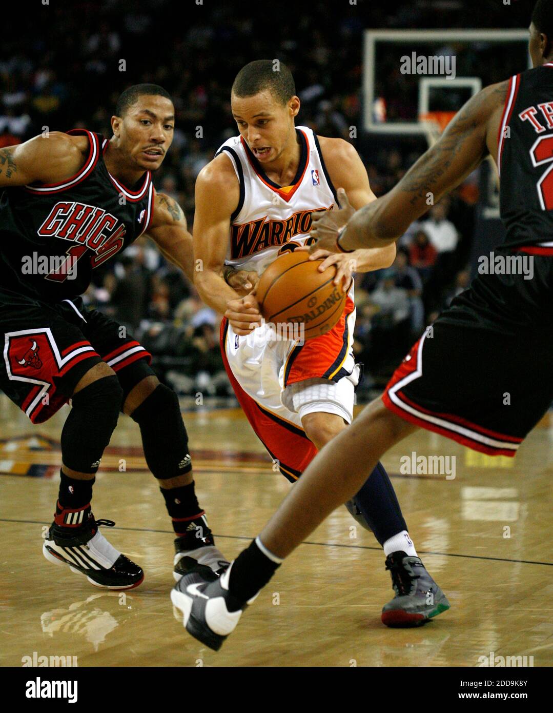 NO FILM, NO VIDEO, NO TV, NO DOCUMENTARY - The Golden State Warriors'  Stephen Curry drives between Chicago Bulls defenders Derrick Rose, left,  and Tyrus Thomas during the first quarter at Oracle