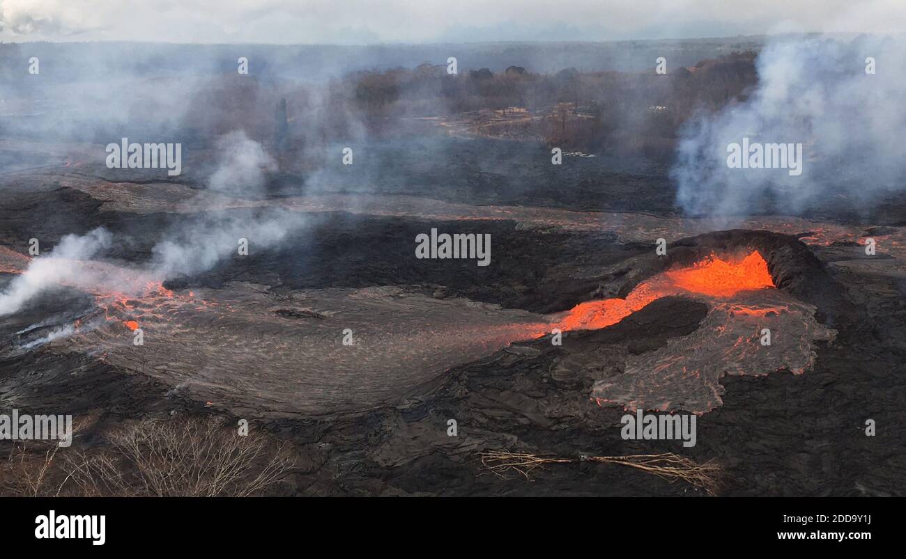 Handout photo of KÄ«lauea Volcano — Spatter Cone. Activity at fissure 6 this morning (May 25, 2018). Lava fountains have built a small spatter cone (black mound) from which lava was spilling out onto the surface and flowing into a small pond (left of the cone). Photo by USGS via ABACAPRESS.COM Stock Photo