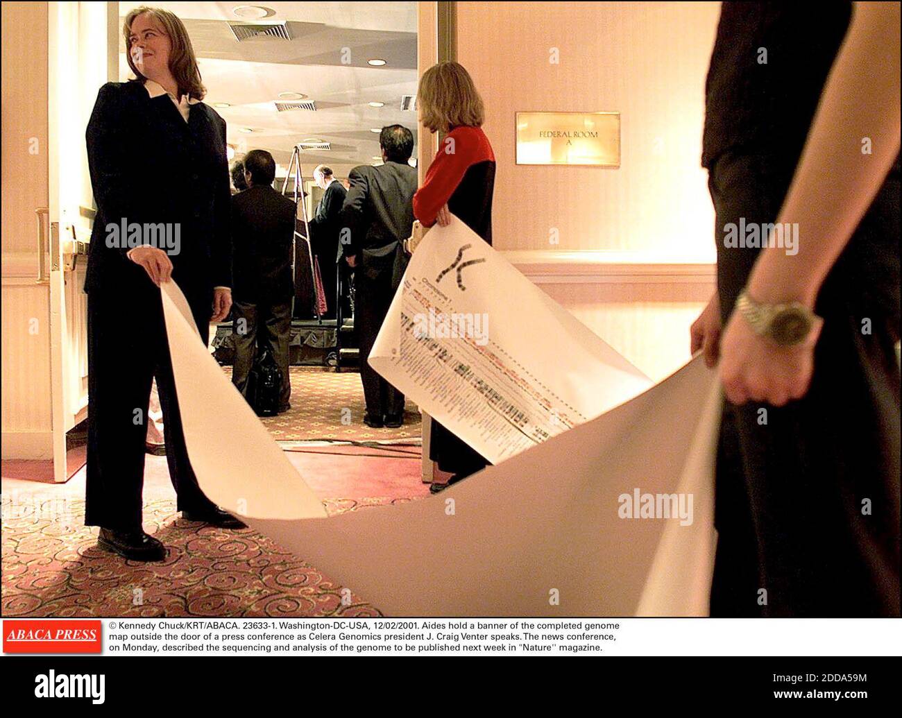NO FILM, NO VIDEO, NO TV, NO DOCUMENTARY - © Kennedy Chuck/KRT/ABACA. 23633-1. Washington-DC-USA, 12/02/2001. Aides hold a banner of the completed genome map outside the door of a press conference as Celera Genomics president J. Craig Venter speaks. The news conference, on Monday, described the se Stock Photo