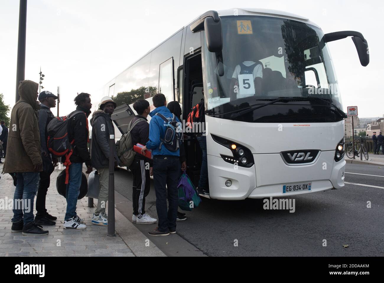 Migrants and refugees load their belongings in a bus during the evacuation  of the Millenaire makeshift camp along the Canal de Saint-Denis near Porte  de la Villette, northern Paris, France, on May