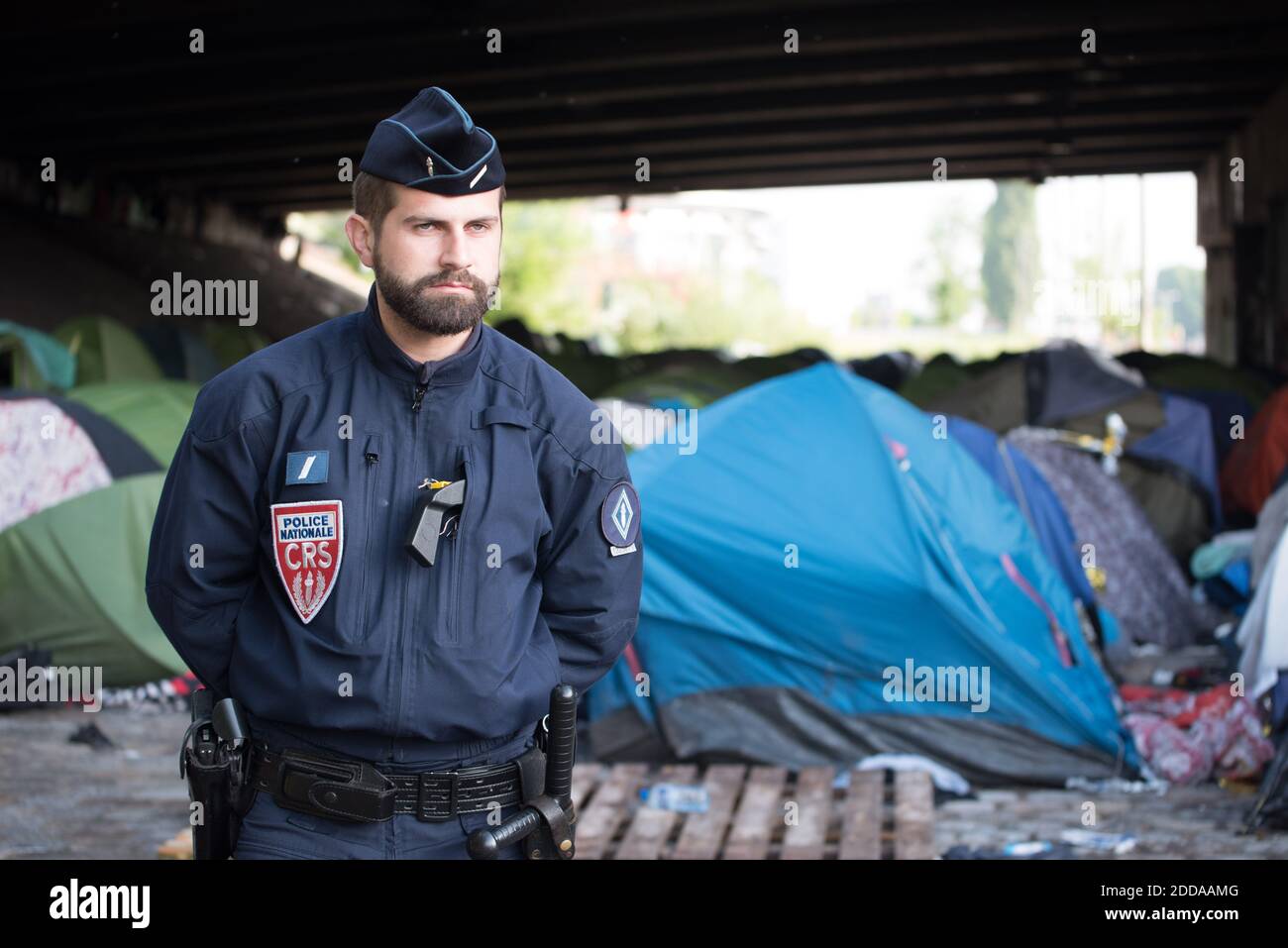 A police officer stands guard at the Millenaire migrants makeshift camp along the Canal de Saint-Denis near Porte de la Villette, northern Paris, France, following its evacuation on May 30, 2018. More than a thousand migrants and refugees were evacuated on early May 30, 2018 from a makeshift camp that had been set up for several weeks along the Canal. Photo by Samuel Boivin/ABACAPRESS.COM Stock Photo