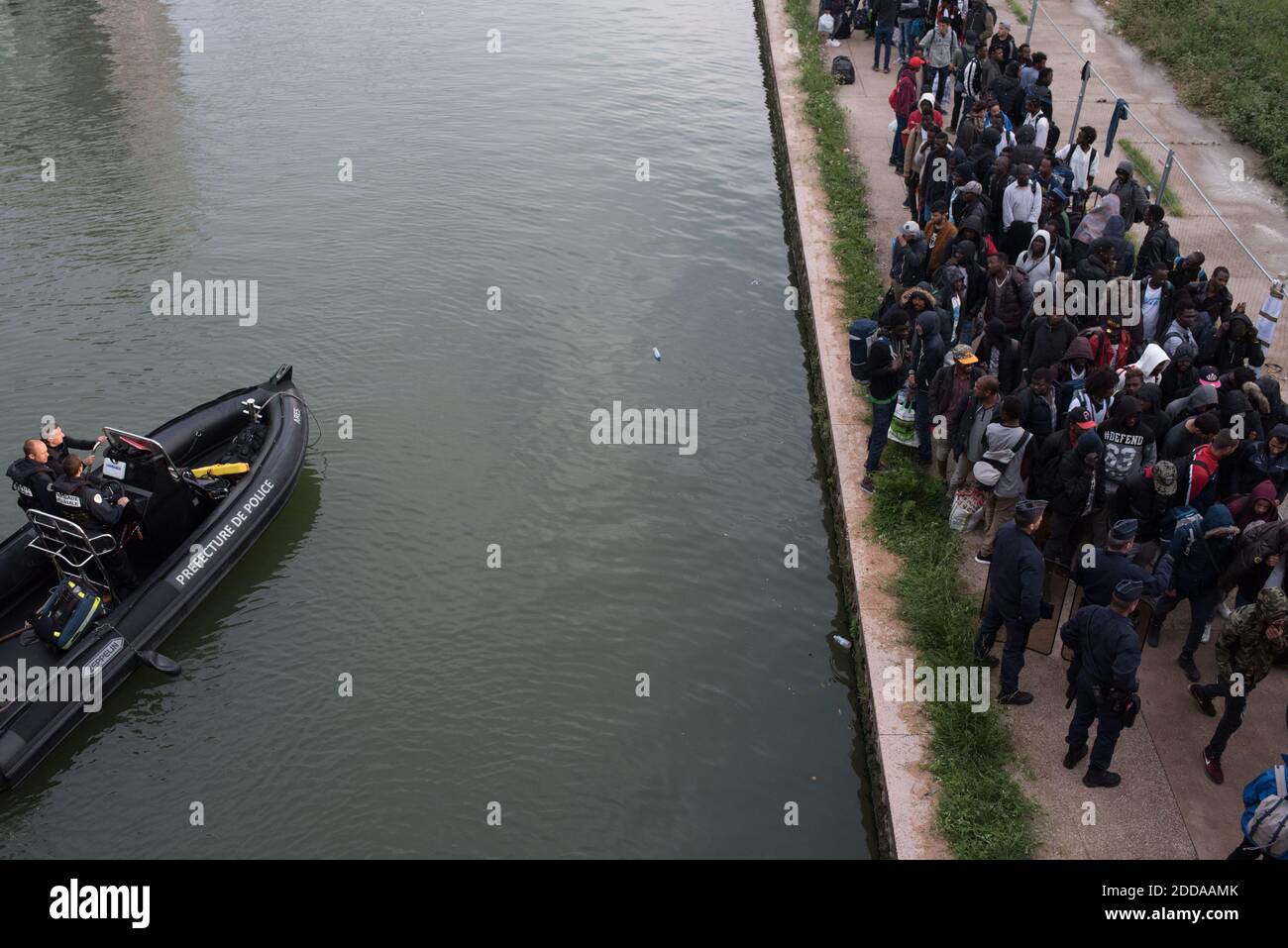 Migrants carry their belongings during the evacuation of the Millenaire makeshift camp along the Canal de Saint-Denis near Porte de la Villette, northern Paris, France, on May 30, 2018. More than a thousand migrants and refugees were evacuated on early May 30, 2018 from a makeshift camp that had been set up for several weeks along the Canal. Photo by Samuel Boivin/ABACAPRESS.COM Stock Photo