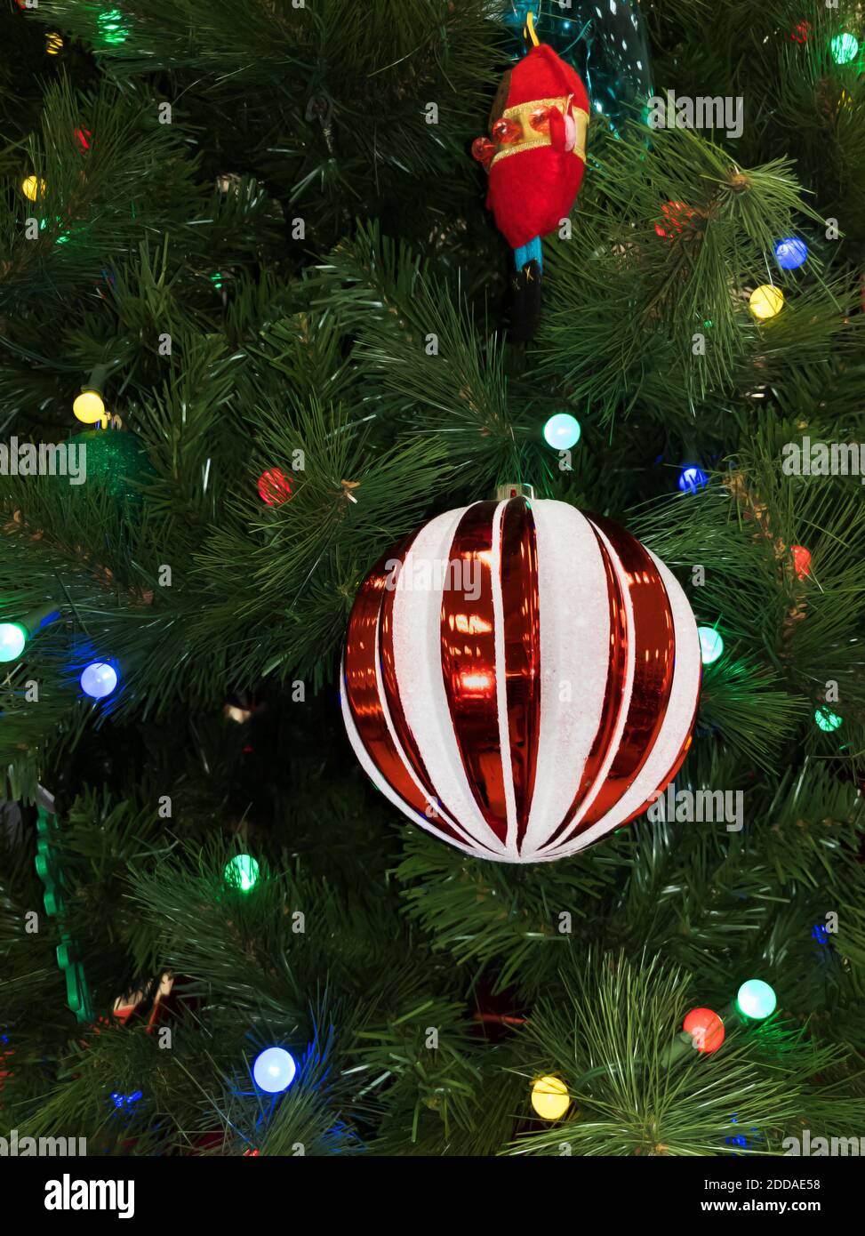 Red and White Ball Ornament on Lit Christmas Tree Stock Photo
