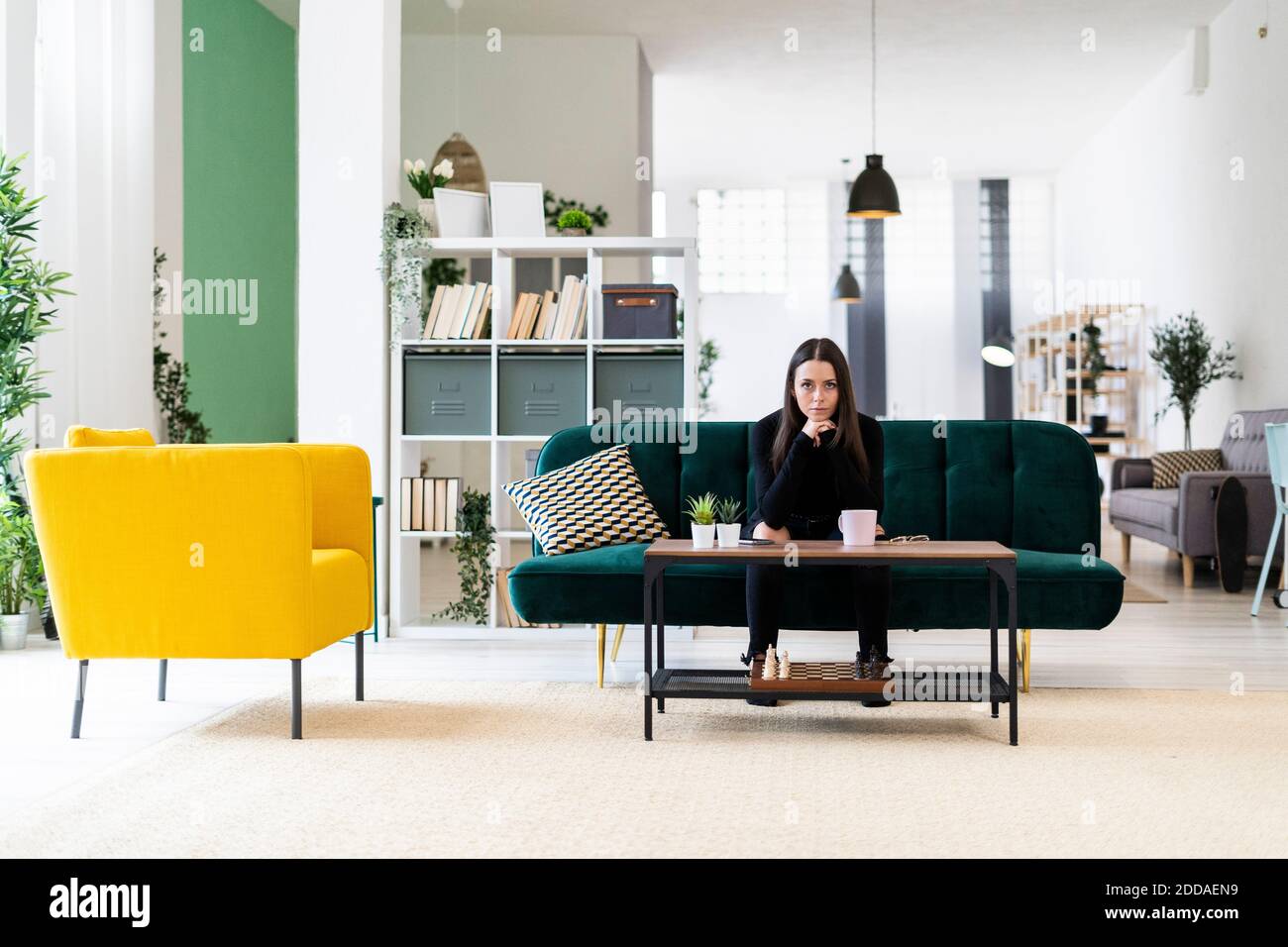 Woman sitting on sofa in living room hi-res stock photography and ...
