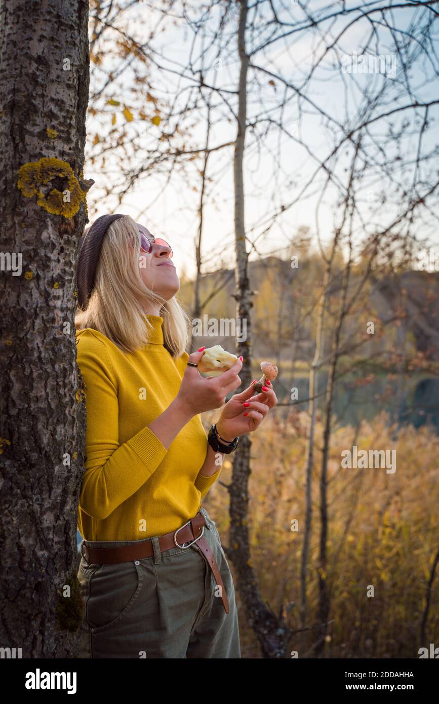 Young woman enjoying life in nature eats an apple and laughs. lifestyle photo Stock Photo
