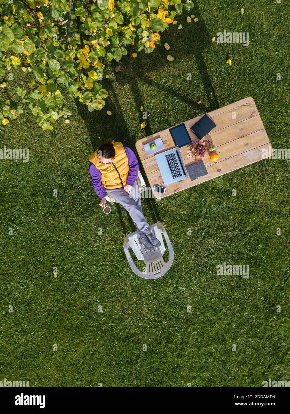 Woman drinking coffee while working on laptop at garden Stock Photo