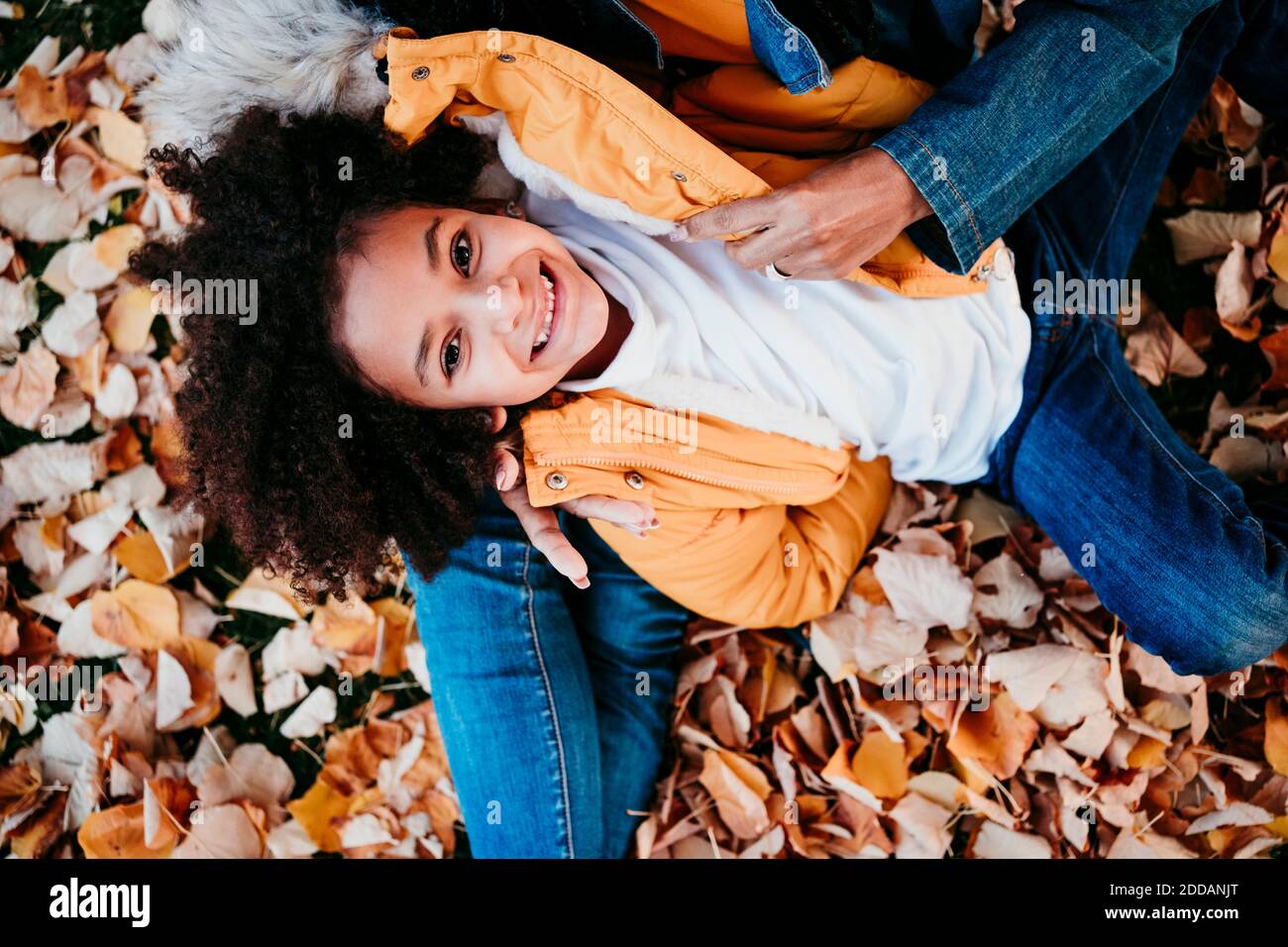 Girl smiling while lying on mother lap at park Stock Photo