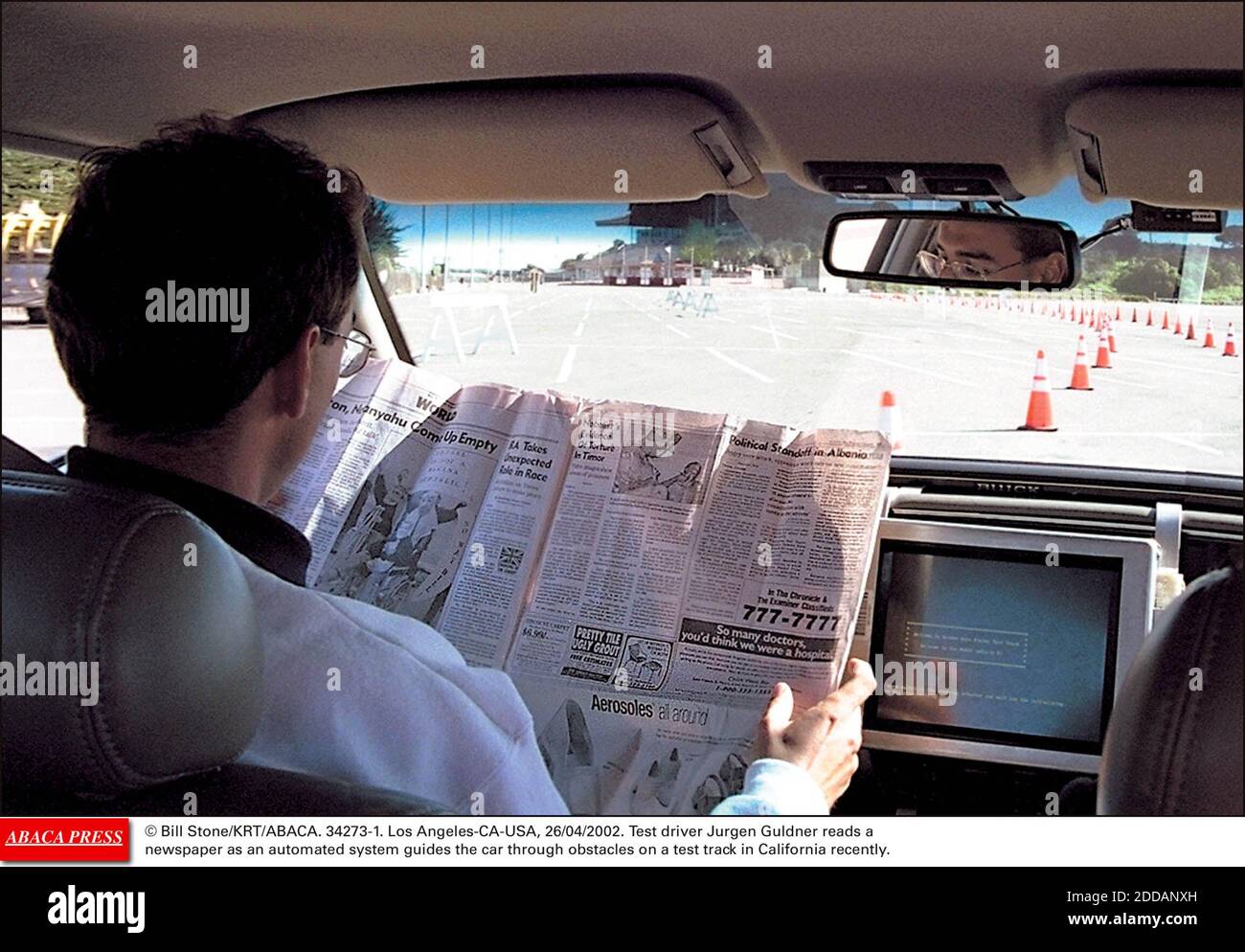 NO FILM, NO VIDEO, NO TV, NO DOCUMENTARY - © Bill Stone/KRT/ABACA. 34273-1. Los Angeles-CA-USA, 26/04/2002. Test driver Jurgen Guldner reads a newspaper as an automated system guides the car through obstacles on a test track in California recently. Stock Photo