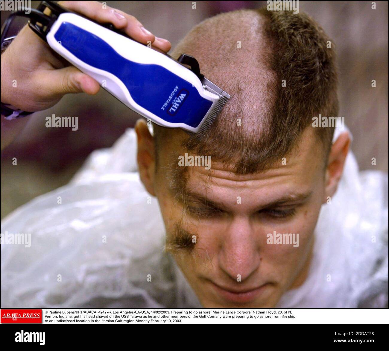NO FILM, NO VIDEO, NO TV, NO DOCUMENTARY - © Pauline Lubens/KRT/ABACA. 42427-7. Los Angeles-CA-USA, 14/02/2003. Preparing to go ashore, Marine Lance Corporal Nathan Floyd, 20, of N. Vernon, Indiana, got his head shaved on the USS Tarawa as he and other members of the Golf Comany were preparing to Stock Photo