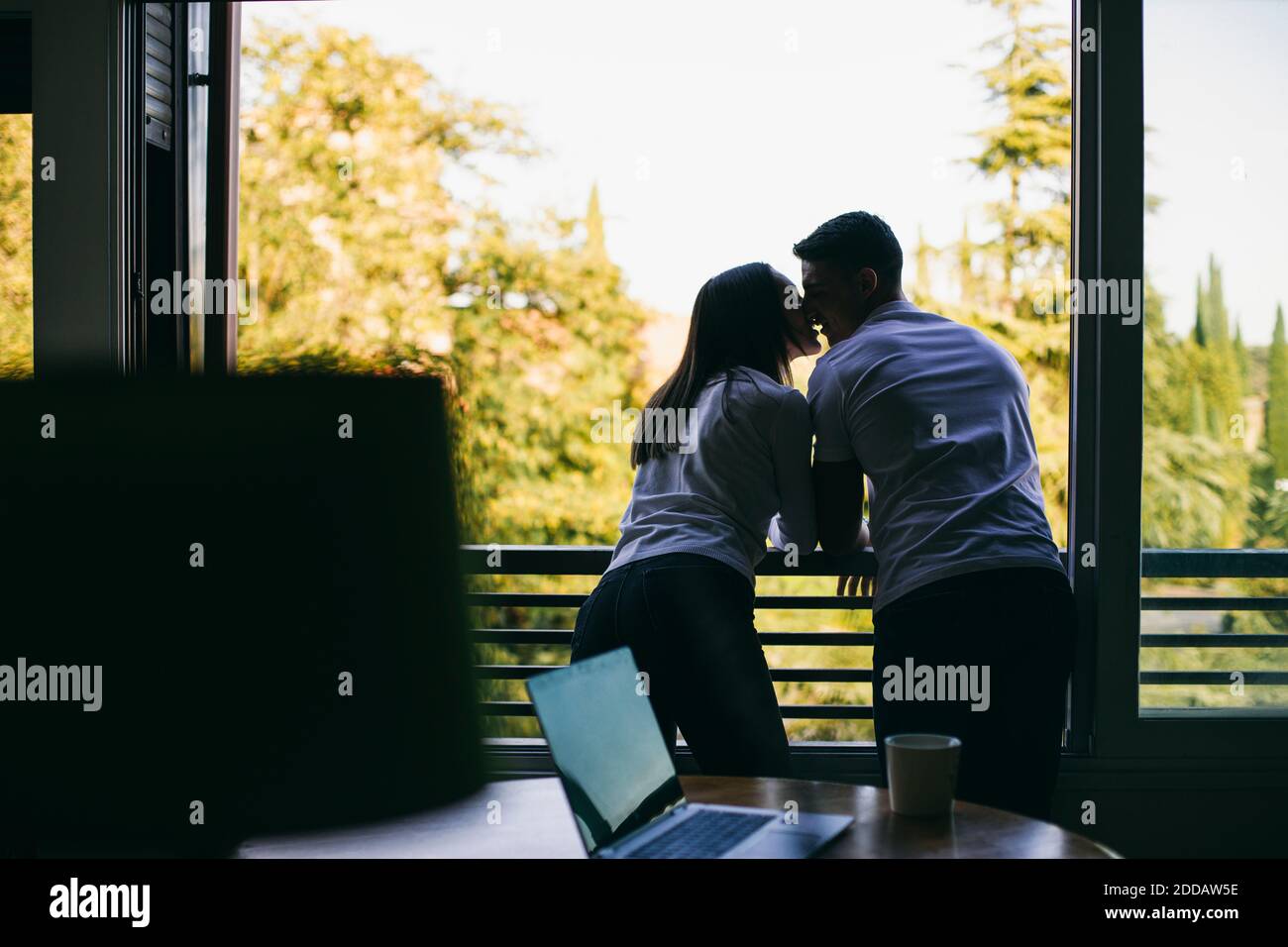 Couple kissing while standing at balcony Stock Photo