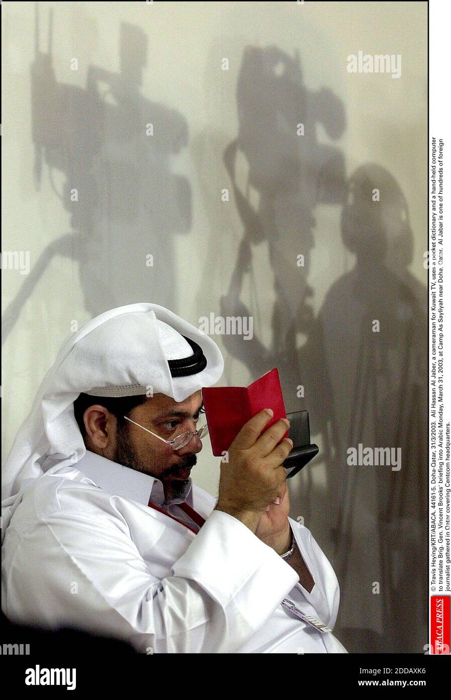 NO FILM, NO VIDEO, NO TV, NO DOCUMENTARY - © Travis Heying/KRT/ABACA. 44161-5. Doha-Qatar, 31/3/2003. Ali Hassan Al Jaber, a cameraman for Kuwait TV, uses a pocket dictionary and a hand-held computer to translate Brig. Gen. Vincent Brooks' briefing into Arabic Monday, March 31, 2003, at Camp As Sa Stock Photo