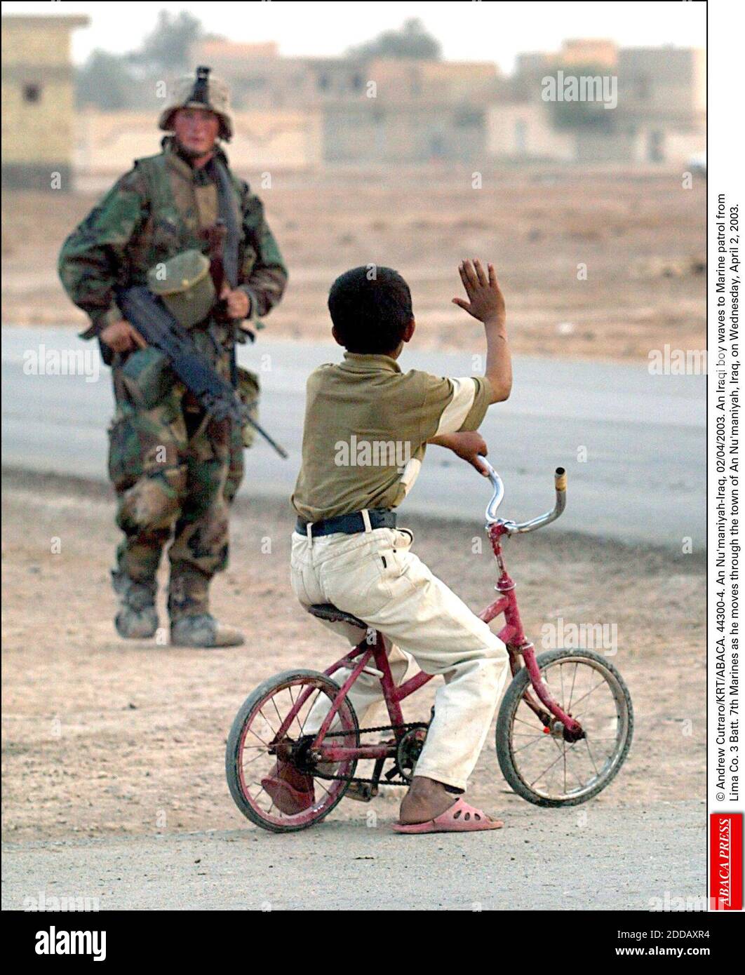 NO FILM, NO VIDEO, NO TV, NO DOCUMENTARY - © Andrew Cutraro/KRT/ABACA. 44300-4. An Nu'maniyah-Iraq, 02/04/2003. An Iraqi boy waves to Marine patrol fromLima Co. 3 Batt. 7th Marines as he moves through the town of An Nu'maniyah, Iraq, on Wednesday, April 2, 2003. Stock Photo