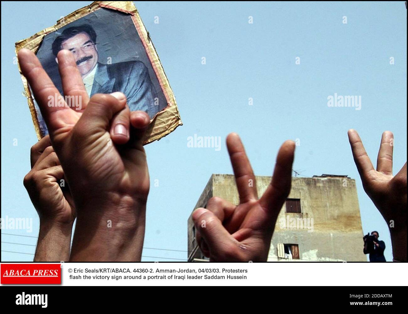 NO FILM, NO VIDEO, NO DOCUMENTARY - © Eric Seals/KRT/ABACA. 44360-2. Amman-Jordan, 04/03/03. Protesters flash the victory sign around a portrait of Iraqi leader Saddam Hussein Stock Photo - Alamy