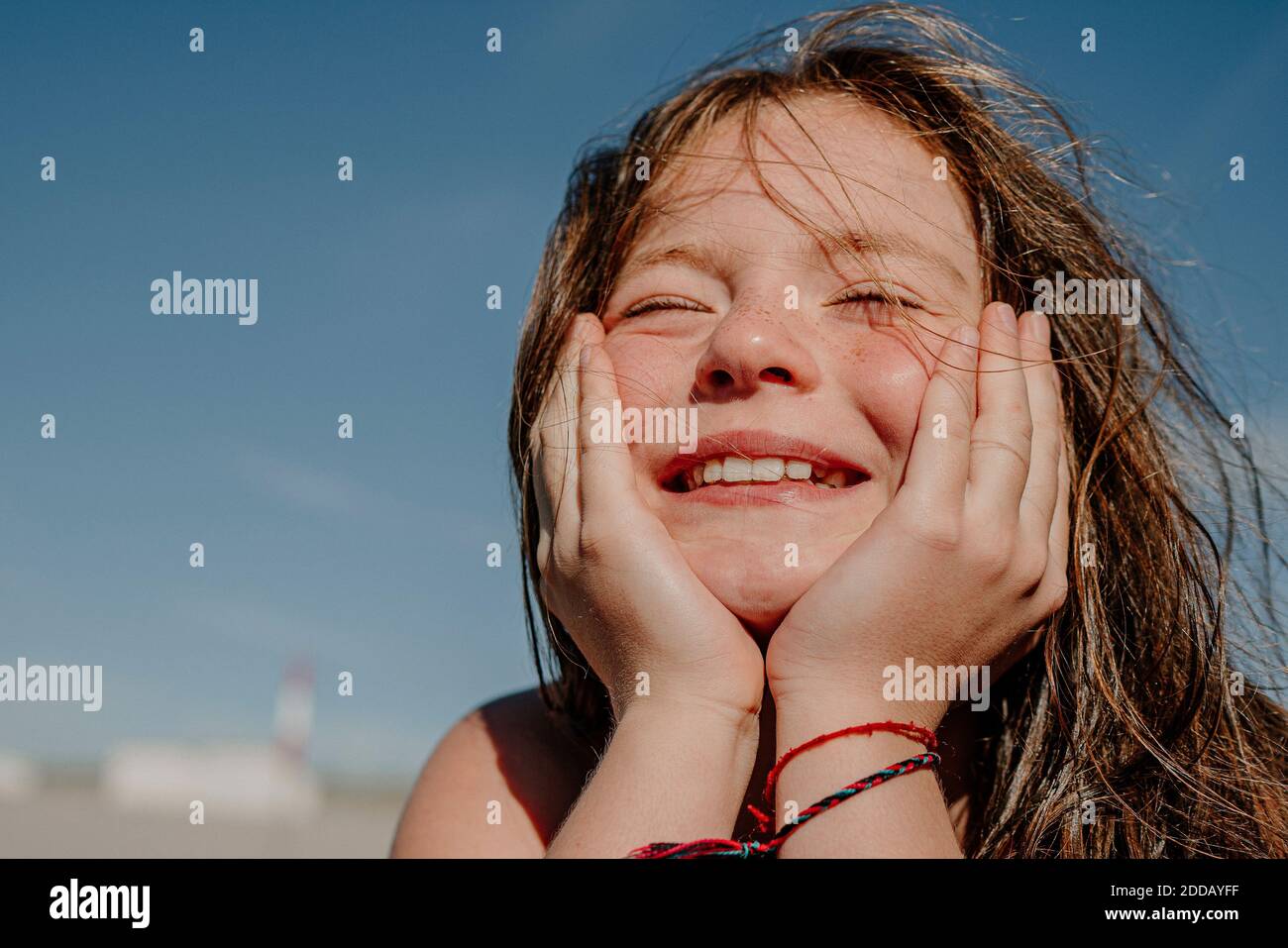 Girl with hand on chin during sunny day Stock Photo