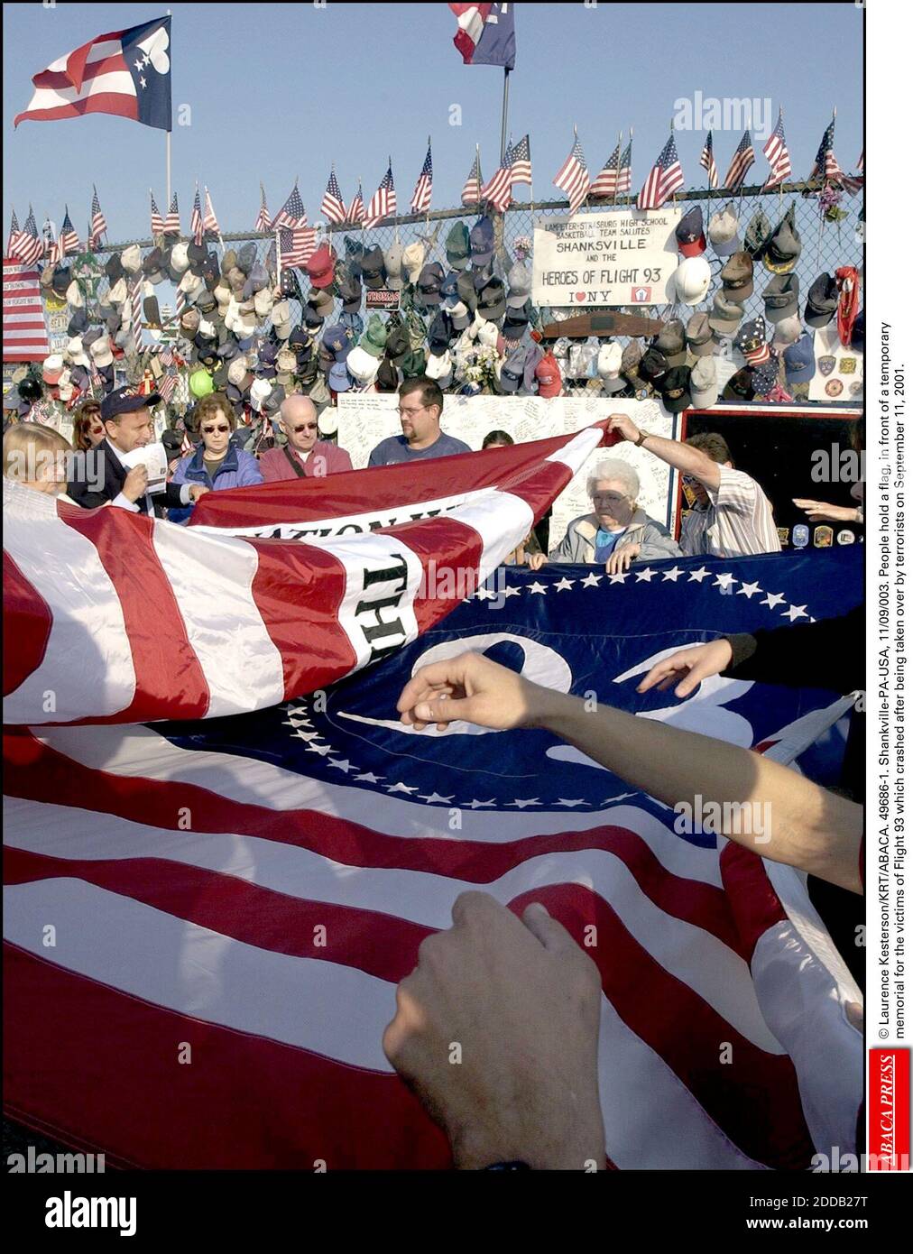 NO FILM, NO VIDEO, NO TV, NO DOCUMENTARY - © Laurence Kesterson/KRT/ABACA. 49686-1. Shankville-PA-USA, 11/09/003. People hold a flag, in front of a temporary memorial for the victims of Flight 93 which crashed after being taken over by terrorists on September 11, 2001. Stock Photo