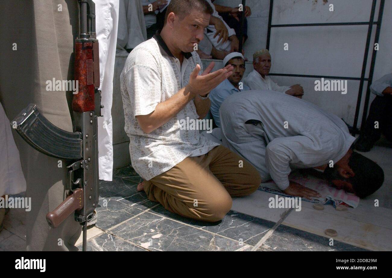 NO FILM, NO VIDEO, NO TV, NO DOCUMENTARY - © Travis Heying/KRT/ABACA. 50590-3. Baghdad-Iraq, 31/08/2003. Under the eye of an armed guard, men pray inside the al Kadem Mosque in Baghdad recently. After the car bombing death of Ayatollah Mohammed Baqir al-Hakim in August, many Shi'ites in Iraq have Stock Photo