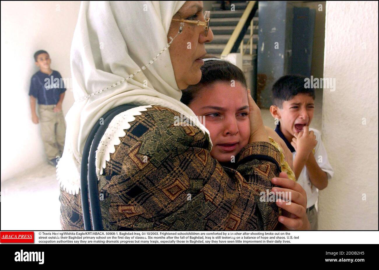 NO FILM, NO VIDEO, NO TV, NO DOCUMENTARY - © Travis Heying/Wichita Eagle/KRT/ABACA. 50908-1. Baghdad-Iraq, 06/10/2003. Frightened schoolchildren are comforted by a teacher after shooting broke out on the street outside their Baghdad primary school on the first day of classes. Six months after the Stock Photo