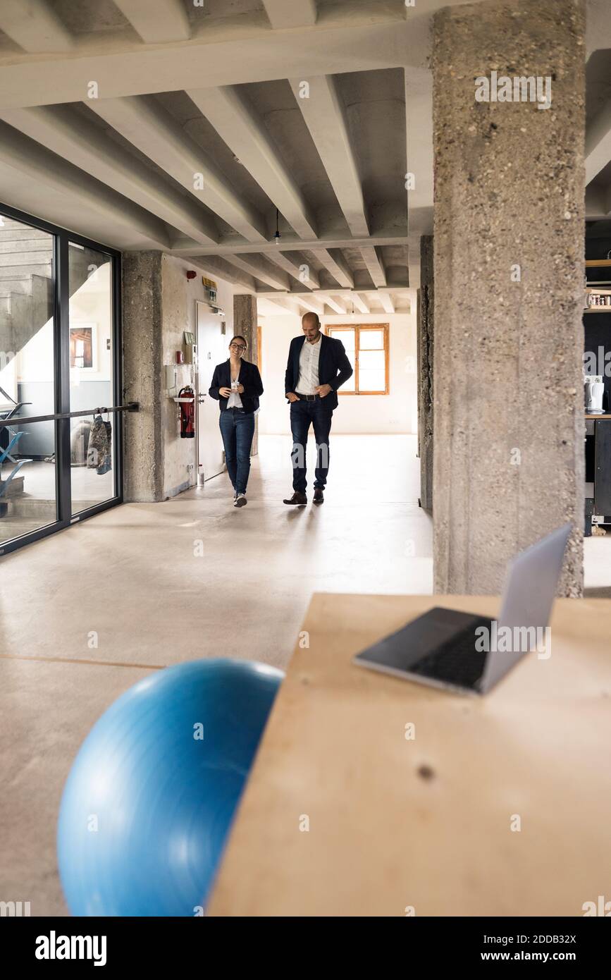 Business people talking while walking in office Stock Photo