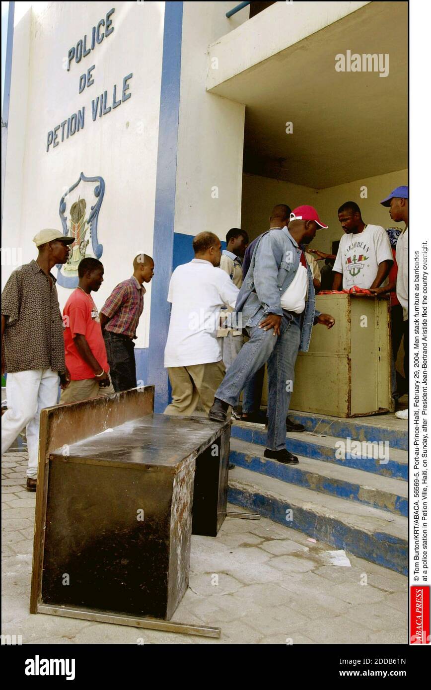 NO FILM, NO VIDEO, NO TV, NO DOCUMENTARY - © Tom Burton/KRT/ABACA. 56569-5. Port-au-Prince-Hati, February 29, 2004. Men stack furniture as barricades at a police station in Petion Ville, Haiti, on Sunday, after President Jean-Bertrand Aristide fled the country overnight. Stock Photo