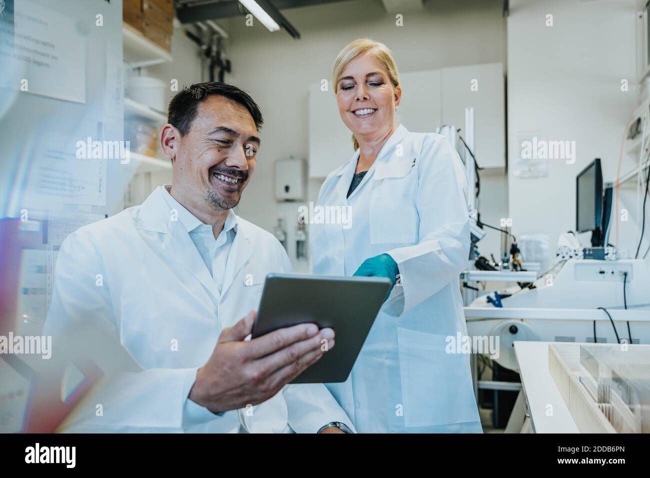 Scientist smiling while using digital tablet at laboratory Stock Photo