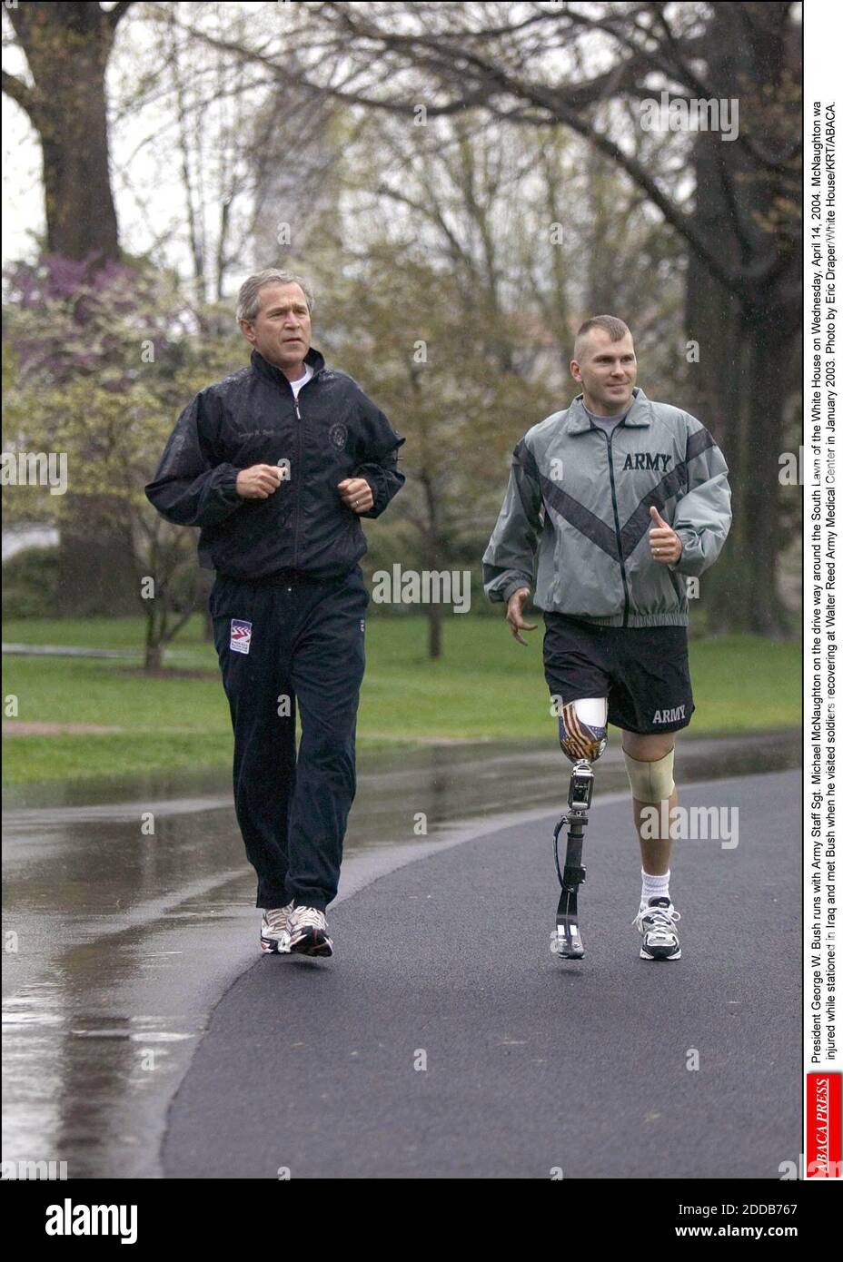 NO FILM, NO VIDEO, NO TV, NO DOCUMENTARY - President George W. Bush runs with Army Staff Sgt. Michael McNaughton on the drive way around the South Lawn of the White House on Wednesday, April 14, 2004. McNaughton wa injured while stationed in Iraq and met Bush when he visited soldiers recovering at Walter Reed Army Medical Center in January 2003. Photo by Eric Draper/White House/KRT/ABACA. Stock Photo