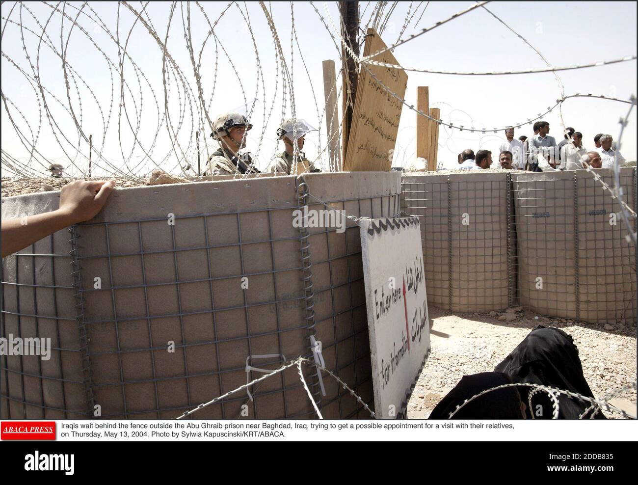 NO FILM, NO VIDEO, NO TV, NO DOCUMENTARY - Iraqis wait behind the fence outside the Abu Ghraib prison near Baghdad, Iraq, trying to get a possible appointment for a visit with their relatives, on Thursday, May 13, 2004. Photo by Sylwia Kapuscinski/KRT/ABACA. Stock Photo