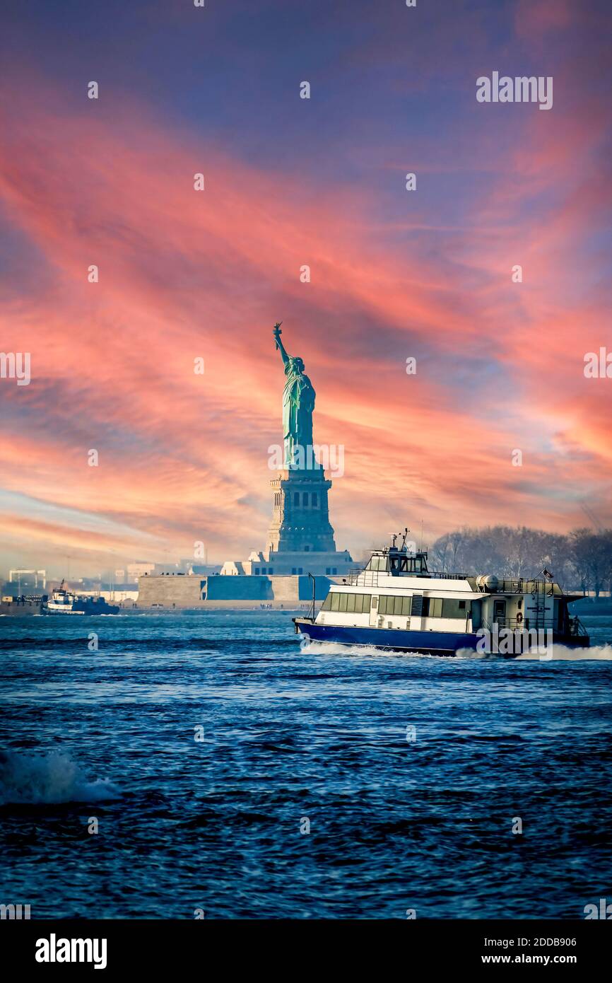 Statue of Liberty and boat at Hudson River against sky during sunset