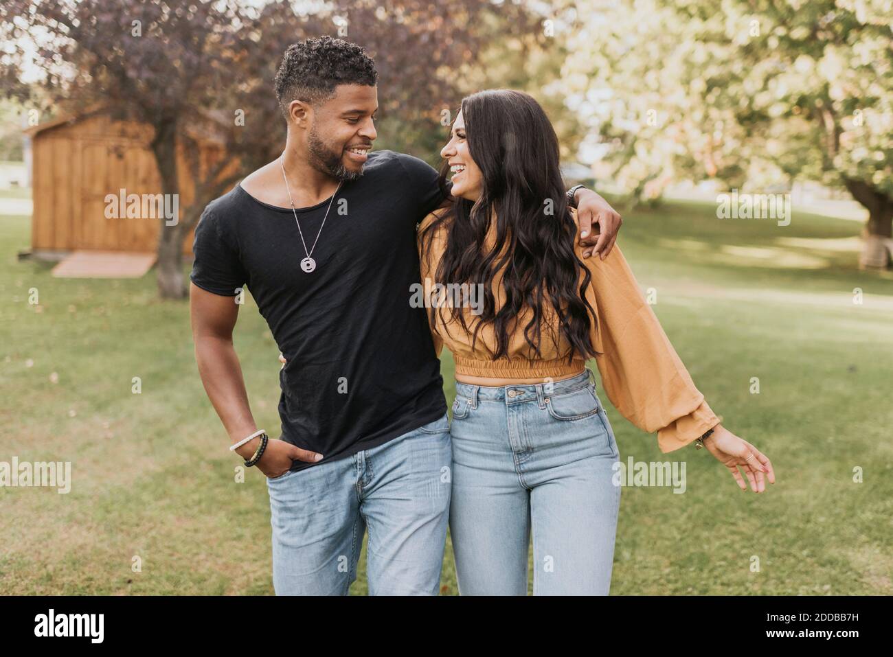 Smiling couple looking at each other while walking at backyard Stock Photo