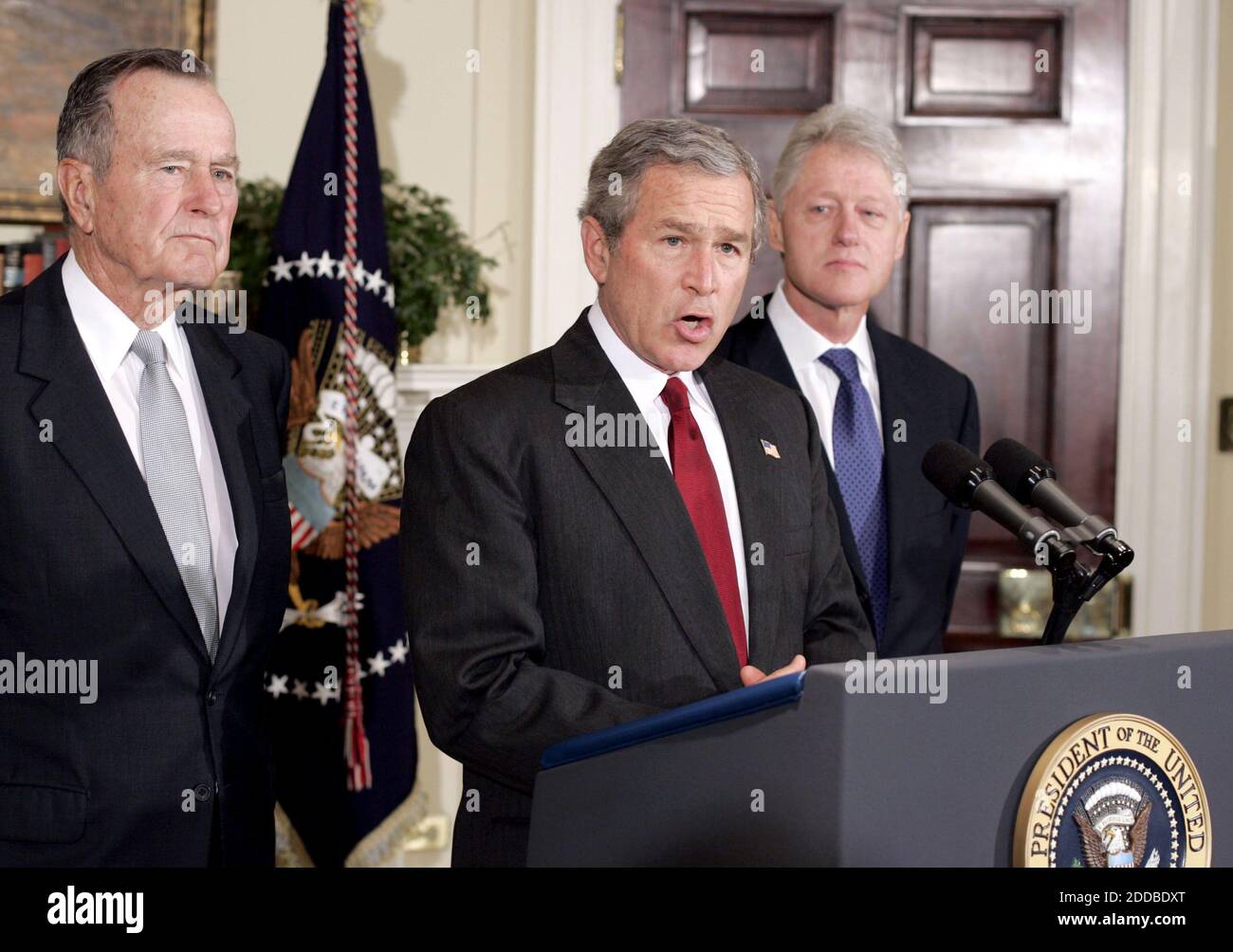 NO FILM, NO VIDEO, NO TV, NO DOCUMENTARY - President George W. Bush , flanked by former Presidents Bill Clinton (R) and George H. Bush (L), makes an appeal to Americans for donations to aid victims of last week's tsunami, while at the White House January 3, 2005. Bush brought together former presidents George Bush and Clinton on Monday to launch an appeal for Americans to make a donation to help victims of the South Asia quake and tsunamis. The president's father and Clinton will lead a bipartisan effort to seek out donations both large and small to provide relief assistance to millions left h Stock Photo