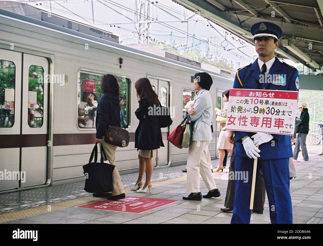 NO FILM, NO VIDEO, NO TV, NO DOCUMENTARY - A security guard holds a sign marking a train car reserved for women only at the Tama Plaza station in Yokohama, Japan, on May 17, 2005. Several train companies introduced the reserved cars to cut down on harassment. Photo by Emi Doi/KRT/ABACA Stock Photo