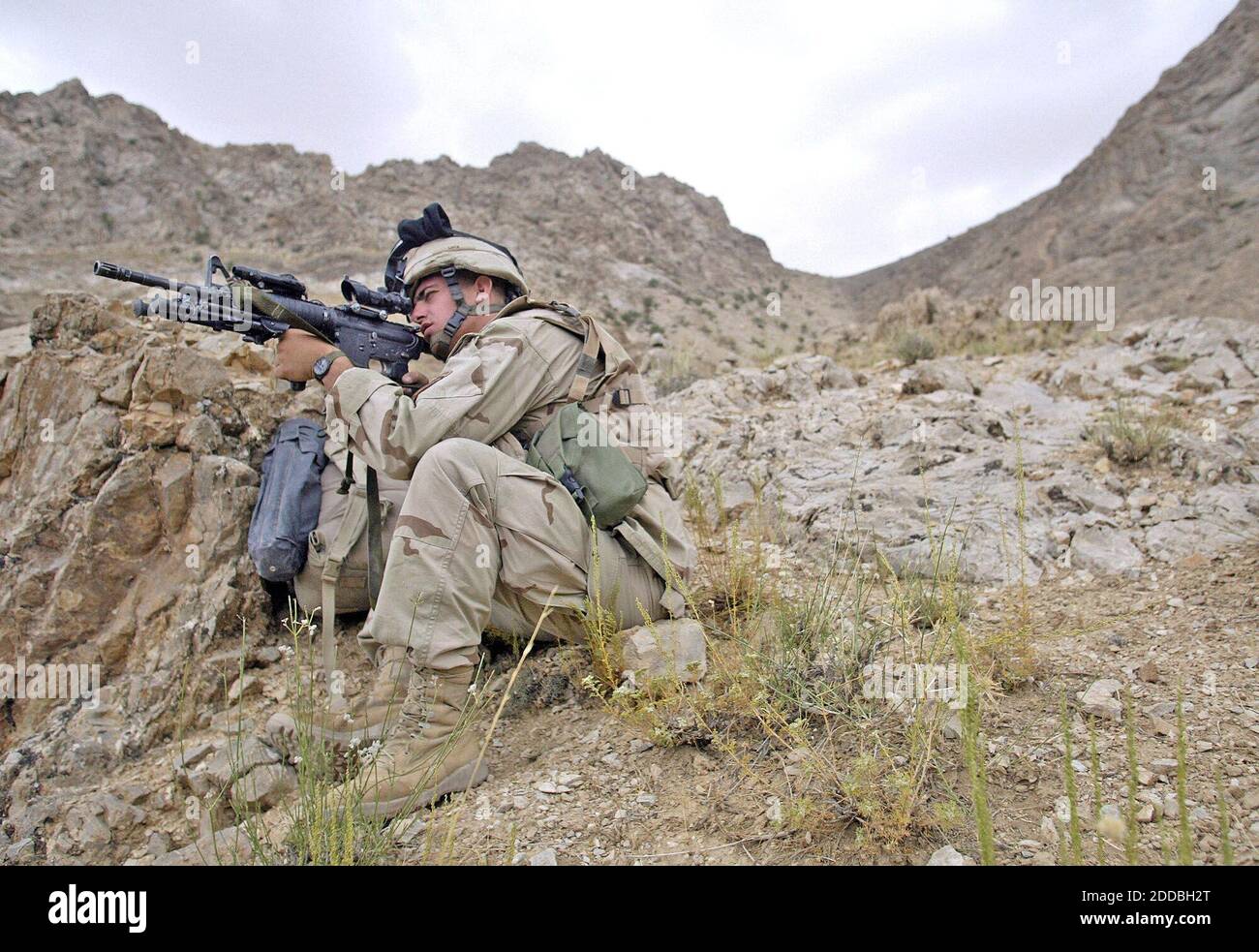 NO FILM, NO VIDEO, NO TV, NO DOCUMENTARY - Sgt. Jay Lutz, of Jarettsville, Maryland, with Battle Company, 2nd Batt. Airborne, 503rd Infantry, 173rd Airborne Brigade, scans the nearby rocks for Taliban fighters while participating in Operation Como in the Deh Chopan District of Zabul Province, Afghanistan, on August 10, 2005. Photo by Tom Pennington/Fort Worth Star-Telegram/KRT/ABACAPRESS.COM. Stock Photo