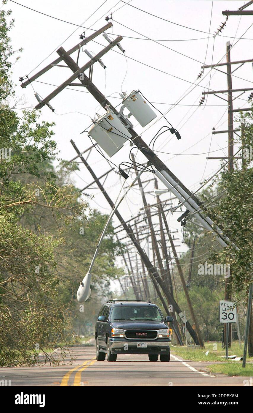 NO FILM, NO VIDEO, NO TV, NO DOCUMENTARY - A vehicle winds through leaning  poles and downed power lines in Port Arthur, Texas, on Monday September 26,  2005. Photo by Ron T.Ennis/Fort