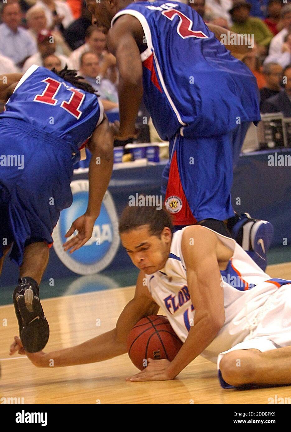 NO FILM, NO VIDEO, NO TV, NO DOCUMENTARY - Florida's Joakim Noah, bottom, dives for a loose ball against South Alabama's Carlos Smith (11) and Mario Jointer, in the first round of the NCAA tournament on March 16, 2006, at the Veterans Memorial Arena in Jacksonville, FL, USA. Florida won 76-50. Photo by Gary W. Green/Orlando Sentinel/KRT/Cameleon/ABACAPRESS.COM Stock Photo
