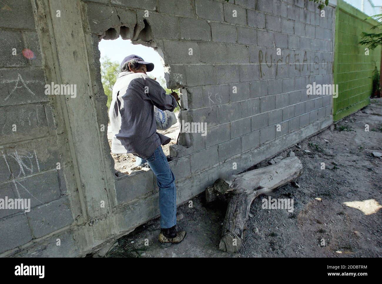 NO FILM, NO VIDEO, NO TV, NO DOCUMENTARY - A man climbs through one of the many holes in a fence along the U.S. bordner near Matamoros, Mexico on April 19, 2006. U.S. President George W. Bush is addressing immigration and border security in a televised address on Monday, May 15, 2006. Photo by Tom Pennington/Fort Worth Star-Telegram/KRT/ABACAPRESS.COM Stock Photo