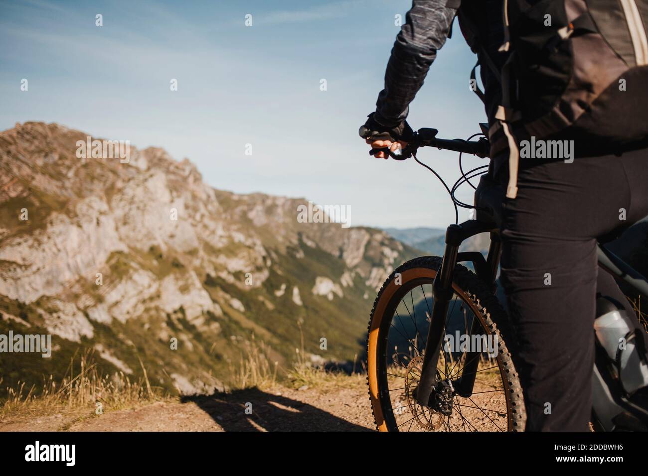 Female mountain biker on electric bicycle standing against mountain at Somiedo Natural Park, Spain Stock Photo