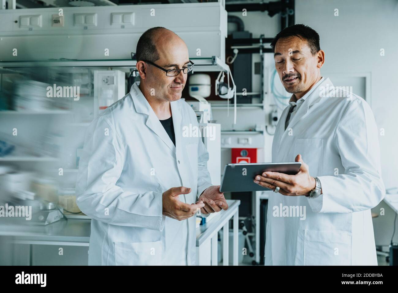 Scientist using digital tablet while standing at laboratory Stock Photo