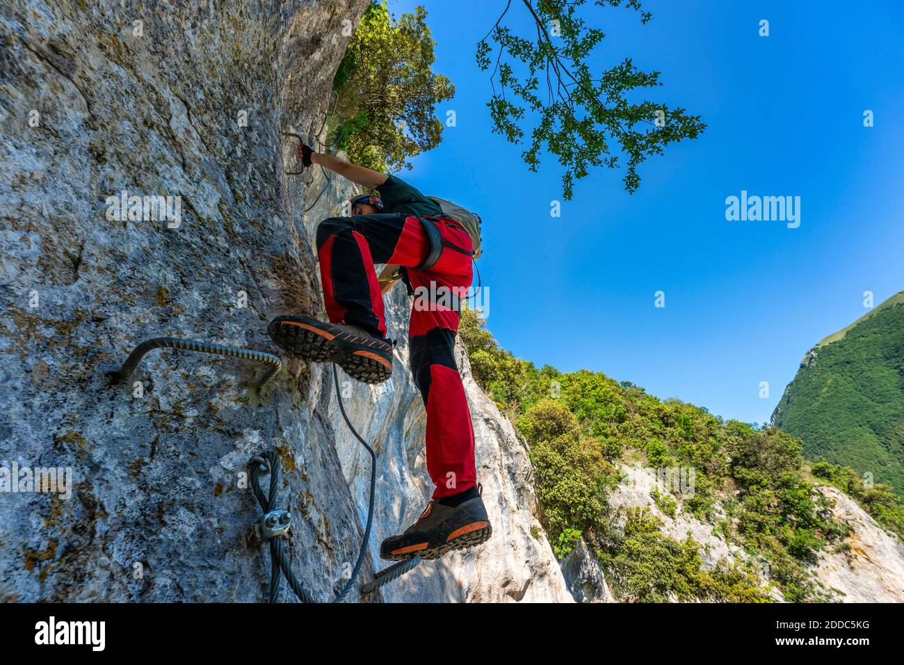 Male rock climber ascending steep wall in Apennine Mountains Stock Photo
